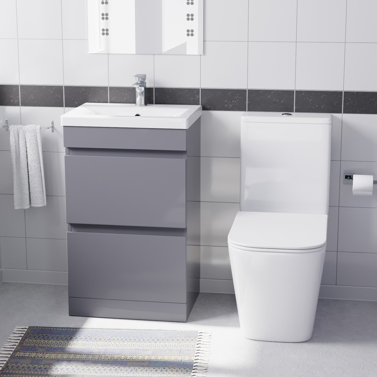 Bathroom setup with a gray vanity unit, white sink, and toiletl.